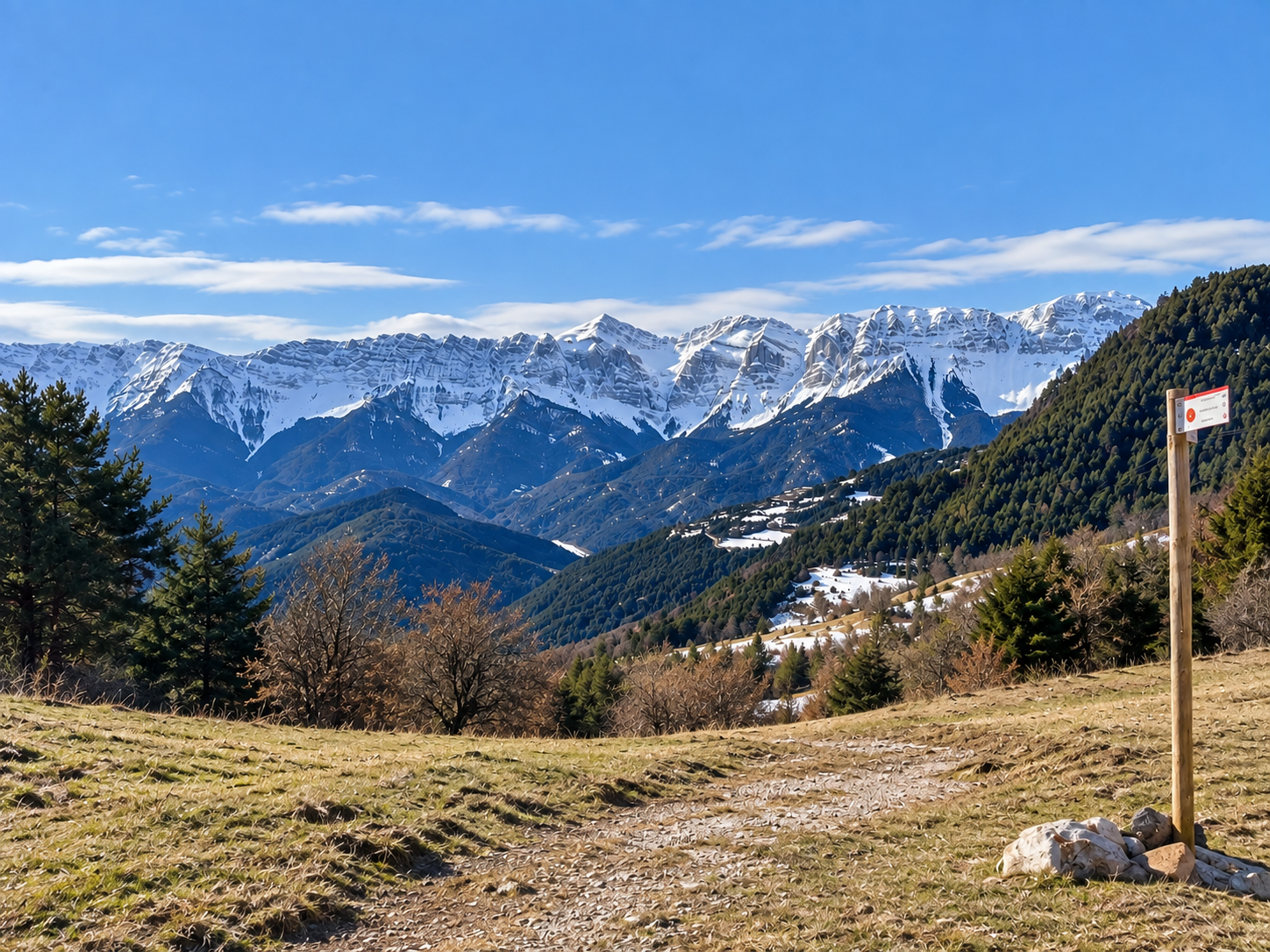 Panoràmica del Cadí nevat amb un cartell de senderisme